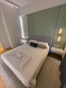 ein Schlafzimmer mit einem großen Bett mit weißer Bettwäsche in der Unterkunft Limak's Diamond Residences in Skopje