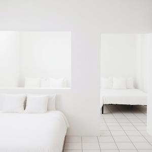 2 witte bedden in een kamer met witte muren bij Departamento Puerto Vallarta in Puerto Vallarta