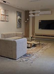 una sala de estar con un sofá y una mesa en اكواخ ساوثرنز, en Ḩaḑram