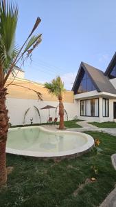 una casa con una palmera en un patio en اكواخ ساوثرنز, en Ḩaḑram 9 fotos más