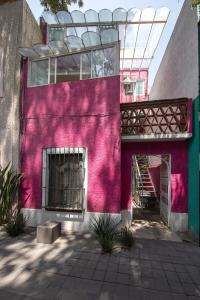 Una fachada rosa de un edificio con una escalera. en Departamentos Mi querido Coyoacán, en Ciudad de México