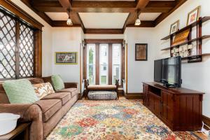 a living room with a couch and a flat screen tv at The ND Rover - Vintage 4BR Home Across St to ND in South Bend