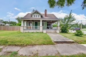 a small green house with a porch at The ND Rover - Vintage 4BR Home Across St to ND in South Bend