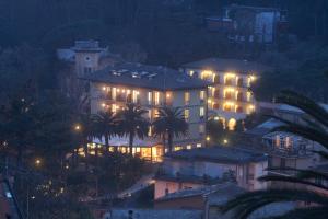 un gran edificio con luces encendidas por la noche en Hotel Villa Adriana en Monterosso al Mare