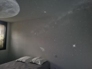 a bedroom with a bed and a wall with stars at Le voyage mystérieux in La Celle-sous-Gouzon