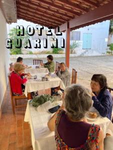 a group of people sitting at tables in a restaurant at Hotel Guarini in Monte Sião +17 photos