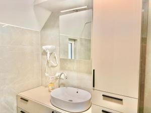 Un baño con un lavabo blanco y un espejo. en ASP Modern Apartments with Balcony & Free Parking, en Viena 50 fotos más