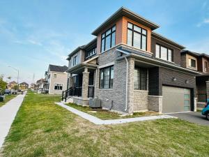 a large brick house with a grass yard at Luxury 4BR Family Retreat in Thorold, Just 10 Mins from Niagara Falls, Clifton Hill & Wineries Free Wi-Fi, Free Parking in Thorold