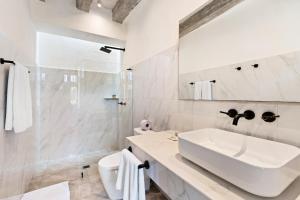 ein weißes Badezimmer mit Waschbecken und Spiegel in der Unterkunft Upper Hotel in Cartagena de Indias