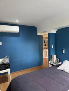 a blue bedroom with a bed and a blue wall at Quarto Vila Madalena in Sao Paulo