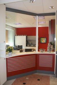 an office lobby with a red wall and a counter at Hotel Villa Adriana in Monterosso al Mare