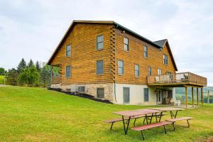 Una casa grande con dos mesas de picnic en frente. en Game Room and Fire Pit Sprawling Westfield Retreat!, en Westfield
