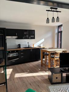 a kitchen with a table and a dining room at Le Clos Urbain in Caudry