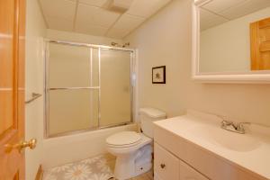 a white bathroom with a toilet and a sink at Walk to Lake Winnisquam Access Cozy Retreat in Winnisquam +18 photos