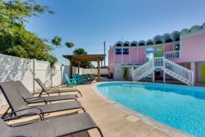 a pool with lounge chairs next to a building at Walk to Beach Unique Family Gem in Pass Christian in Long Beach