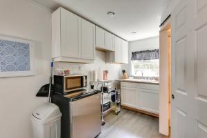 a kitchen with white cabinets and a microwave at 2 Mi to Long Beach Waterfront! Convenient Studio in Long Beach