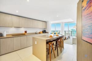 a kitchen with a island with bar stools at Beautiful 1BR Apartment with Ocean View Balcony in Hollywood Beach