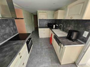 a kitchen with a sink and a counter top at Grande maison conviviale proche de Tours in Hommes
