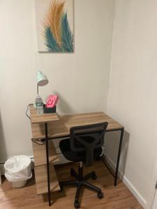 a desk with a chair and a lamp on it at Sammy Place in Newark