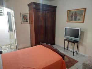 ヴァレンサにあるCasa com um quarto de casal para alugarのベッドとテレビのある寝室