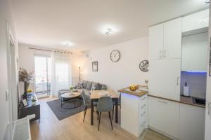a kitchen and a living room with a table in a room at Apartman TRI KRALJA 3 in Banja Koviljača