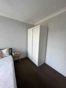 1 dormitorio con armario blanco y cama en Gabriele and André, en Gold Coast