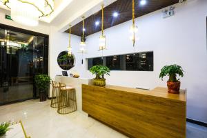 a lobby with a reception desk with potted plants at XI SHANG YUN JIAN Inn in Hanqiyu