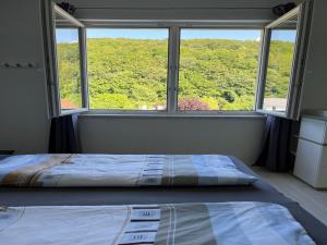 a bed in a room with a large window at Wienerwaldblick in Mauerbach