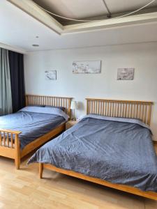 two beds sitting next to each other in a bedroom at Hongdae Residence-2 1min from Hongik Uni station Exit #1 in Seoul