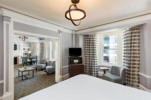 a bedroom with a bed and a living room at Handlery Union Square Hotel in San Francisco