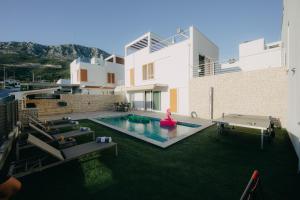 a house with a pool and a ping pong table at TI Amo Holiday House - Heated Pool in Kaštela
