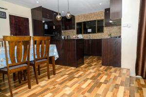a kitchen with a table and two chairs and a kitchen with cabinets at Lautoka Home away from Home in Lautoka