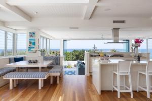 ヌーサヘッズにあるThe Beach Shack: Getaway on Sunshine Beachのキッチン、海の景色を望むダイニングルーム