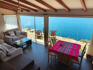 a living room with a view of the ocean at Inti Illimani Lodge in Comunidad Yumani