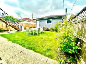 einen Garten mit einem Tisch und Stühlen im Hof in der Unterkunft Cozy Vancouver Retreat with Backyard Oasis in Vancouver