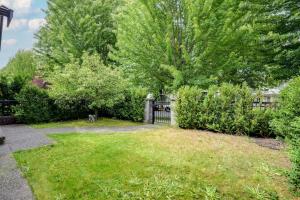 ein Tor in einem Hof mit einem Zaun und Bäumen in der Unterkunft Cozy Vancouver Retreat with Backyard Oasis in Vancouver