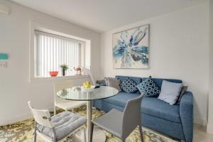 ein Wohnzimmer mit einem blauen Sofa und einem Tisch in der Unterkunft Cozy Vancouver Retreat with Backyard Oasis in Vancouver