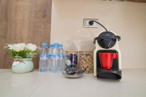 a toaster sitting on a counter with bottles of water at Studio élégant et neuf près de la gare tgv in Casablanca