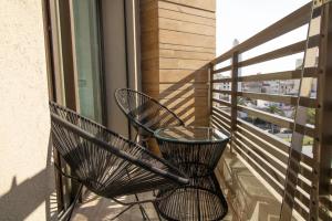 two chairs sitting on the balcony of a building at Studio élégant et neuf près de la gare tgv in Casablanca