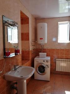 Un baño con lavadora y lavabo. en Подобова для Дорогова, en Izyum