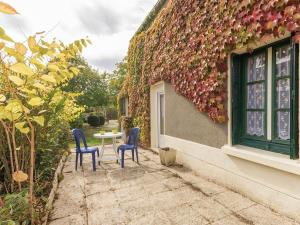two chairs and a table outside of a house at Gîte familial avec jardin clos, à proximité de Guérande et des plages, dans le Parc de Brière - FR-1-306-1070 in Crossac