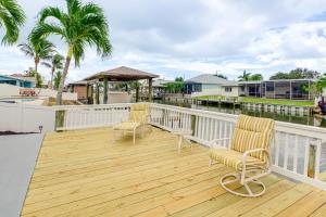 two chairs on a deck with a view of the water at Canal-Front Retreat with Boat Dock on Merritt Island in Indianola