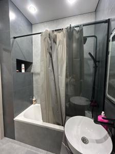 ein Badezimmer mit Dusche und weißem Waschbecken in der Unterkunft Royal Comfort Business Class Apartment in the heart of the ALMATY CITY in Almaty + 1 Foto