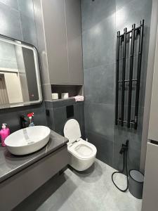 ein Badezimmer mit einer weißen Toilette und einem Waschbecken in der Unterkunft Royal Comfort Business Class Apartment in the heart of the ALMATY CITY in Almaty