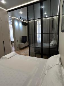 ein Schlafzimmer mit einem Bett und ein Zimmer mit einem TV in der Unterkunft Royal Comfort Business Class Apartment in the heart of the ALMATY CITY in Almaty