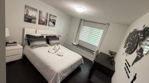 a bedroom with a white bed with a window at Carrie The Gentle Nest 1 in Coquitlam