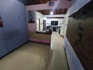 a large room with a kitchen and a hallway at Casa completa in Marituba