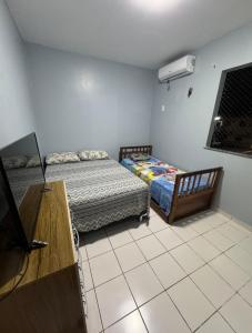 une chambre avec deux lits, un bureau et une télévision dans l'établissement Aluguel de Apt na COP30, à Benjamim