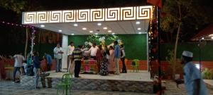 un groupe de personnes se tenant sur une scène dans l'établissement Royal gardens party Hall, à Wālājāpet