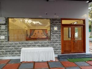 une table blanche assise devant un bâtiment dans l'établissement Royal gardens party Hall, à Wālājāpet